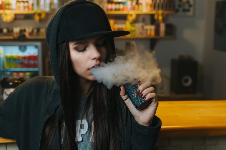 young-pretty-woman-cap-smoke-electronic-cigarette-vape-shop-hip-hop-style-closeup